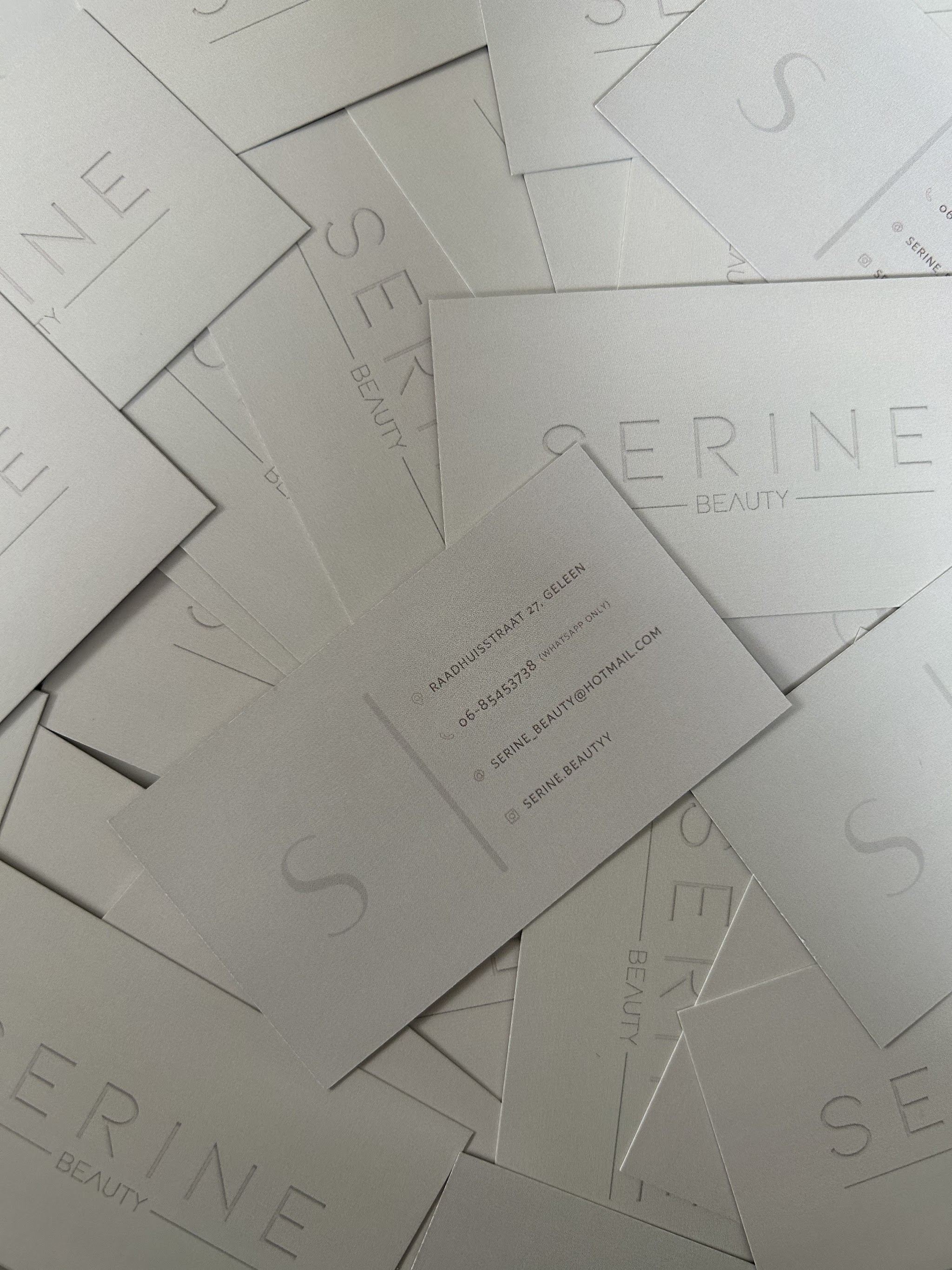 Stapel visitekaartjes van Serine Beauty met het grote S-monogram